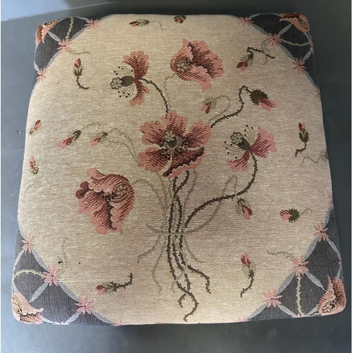 32 - A floral upholstered and studded footstool on bun feet