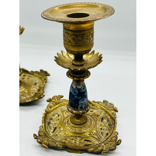 328 - A pair of Aesthetic period brass candlesticks with blue and white ceramic columns and floral fretwor... 