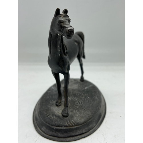 338 - A metal sculpture of a horse on an oval base (H13cm W16cm)