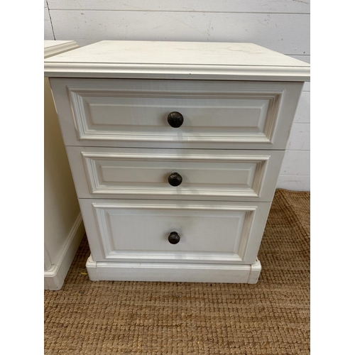 34 - A pair of white painted three drawer bedside tables