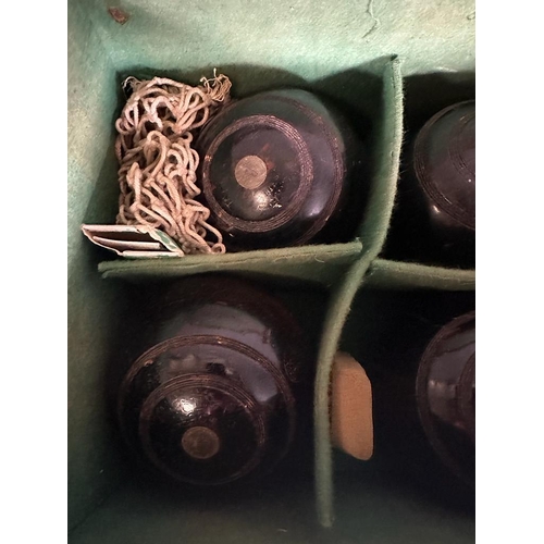 343 - A set of four vintage lawn bowl balls in a brown leather case, monogrammed E.A.P