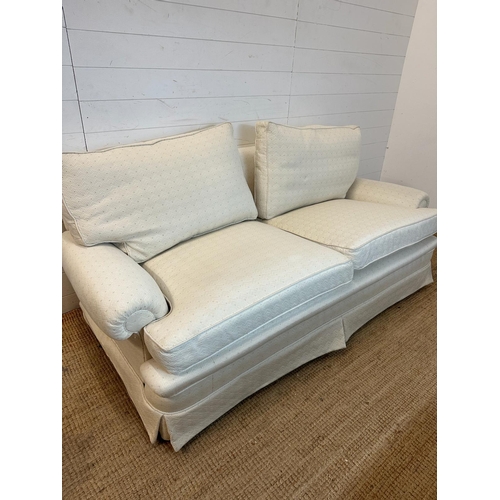 35 - A white upholstered three seater sofa