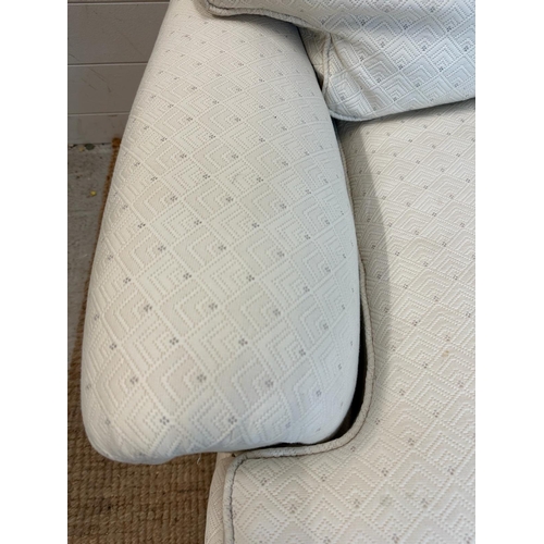 35 - A white upholstered three seater sofa