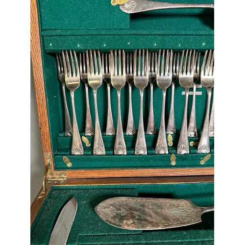 355 - A substantial oak canteen of cutlery with green interior and twelve place settings a Harlequin set.