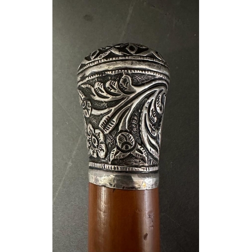 363 - A white metal topped walking cane with a floral pattern