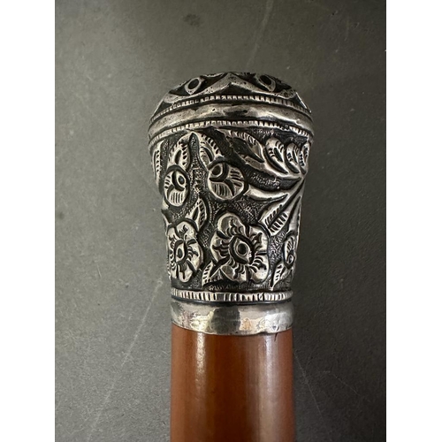 363 - A white metal topped walking cane with a floral pattern