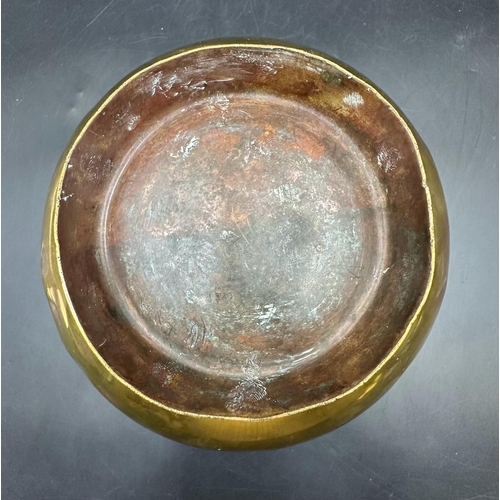 397 - An antique brass bowl with four floral decorations, 21.5cm across and 12cm H