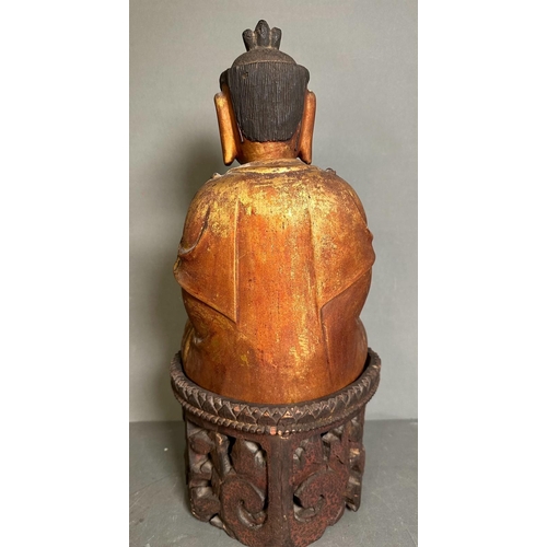 399 - A carved Buddha on carved stand in red and gilt, some damage but additional pieces present for resto... 