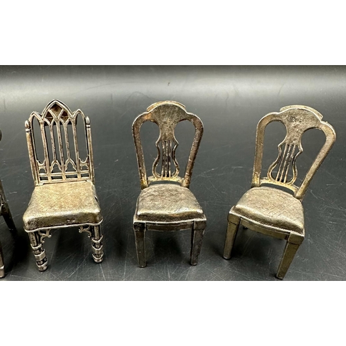 432 - A selection of eight white metal miniature chairs, various styles.