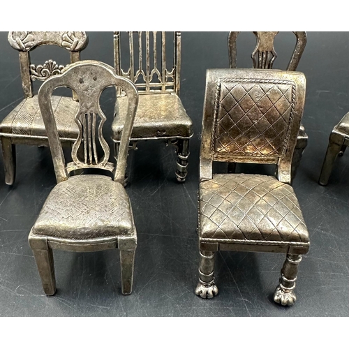 432 - A selection of eight white metal miniature chairs, various styles.