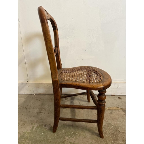 44 - A child's cane seated spoon back chair carved and with turned stretchers