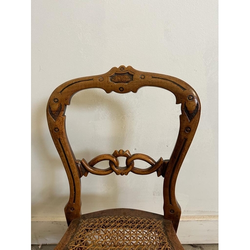 44 - A child's cane seated spoon back chair carved and with turned stretchers