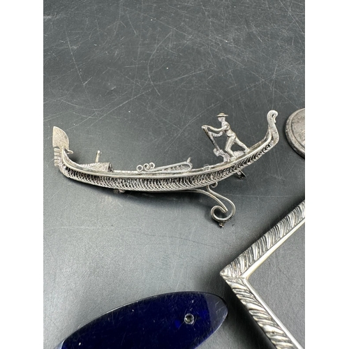 440 - A selection of silver curios to include a silver backed brush, Venetian gondola on a blue glass base... 