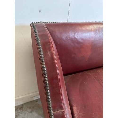 45 - A two seater red leather bench seat with brass studded detail AF