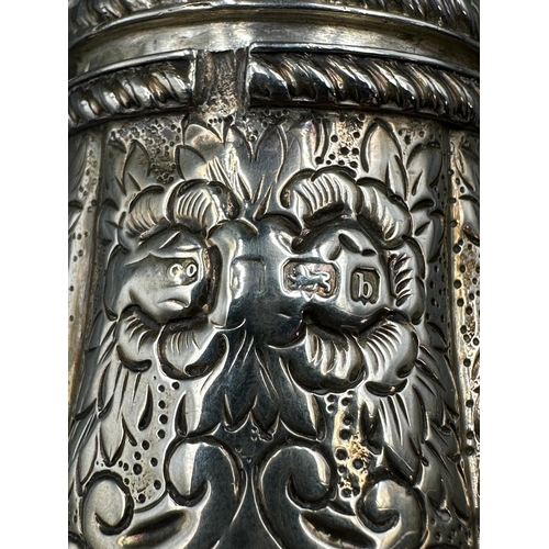 452 - An ornate, foliate decorated, sugar shaker on four hoof feet with obscure hallmarks. Approximate tot... 