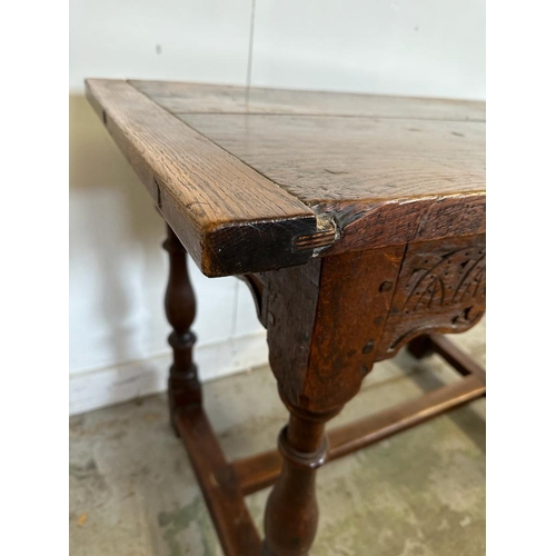 49 - An oak carved side table on turned legs with cross stretchers (H77cm W102cm D59cm)