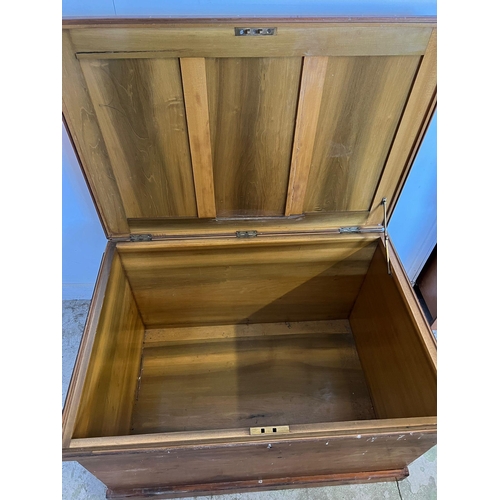 50 - A large pine panelled blanket box or chest with brass drop handles to sides (H70cm W109cm D73cm)