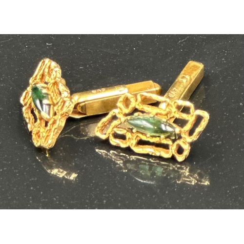 509 - A pair of 18ct gold cuff links with central green stones, hallmarked for London, bearing the makers ... 