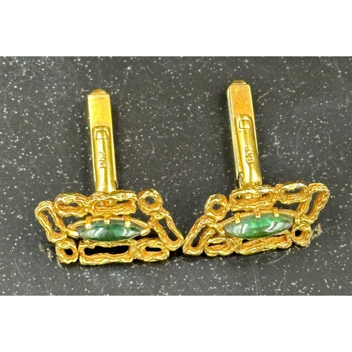 509 - A pair of 18ct gold cuff links with central green stones, hallmarked for London, bearing the makers ... 