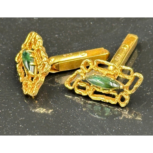 509 - A pair of 18ct gold cuff links with central green stones, hallmarked for London, bearing the makers ... 