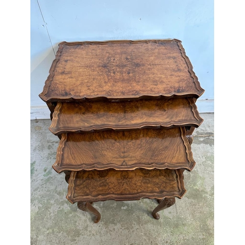 52 - A nest of four bur walnut side tables with crimped tops on splayed feet (H55cm W55cm D37cm)