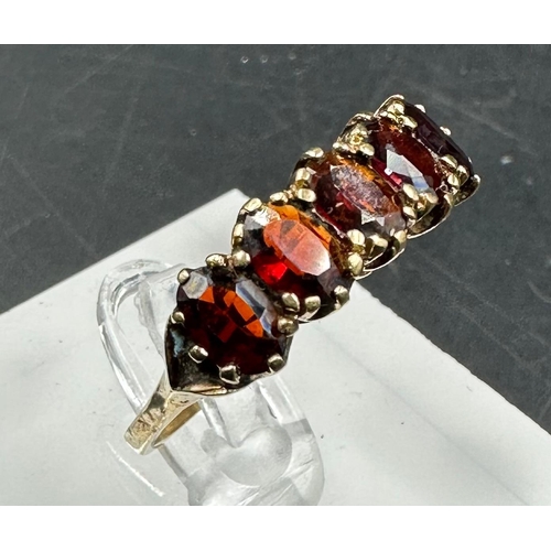 528 - A 9ct gold carved claw set five stone garnet ring size R