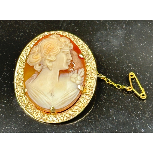 529 - A 9ct gold cameo brooch of a lady in a classical pose with a safety chain