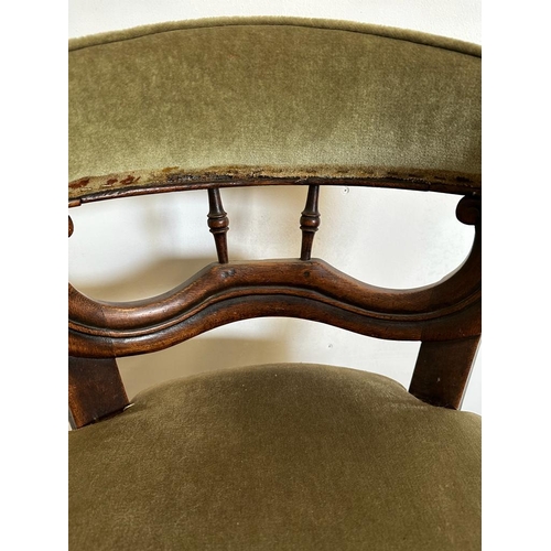 56 - A mahogany framed barrel back wing chair upholstered in green