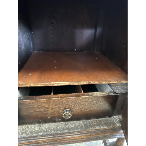 58 - An oak dresser base with two central drawers flanked by two cupboards with carved fronts and relief ... 