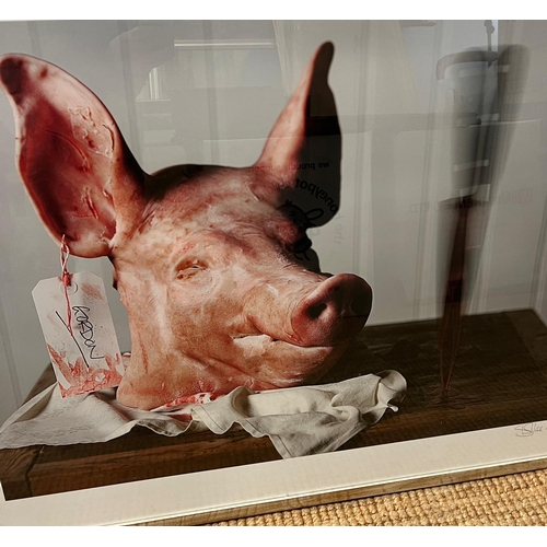 658 - A signed framed print of Gordon The Pig, The pigs head sit on a butchers block with a swing tag 