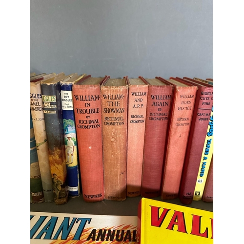 704 - A selection of books and annuals to include Just William, Biggles and Valiand