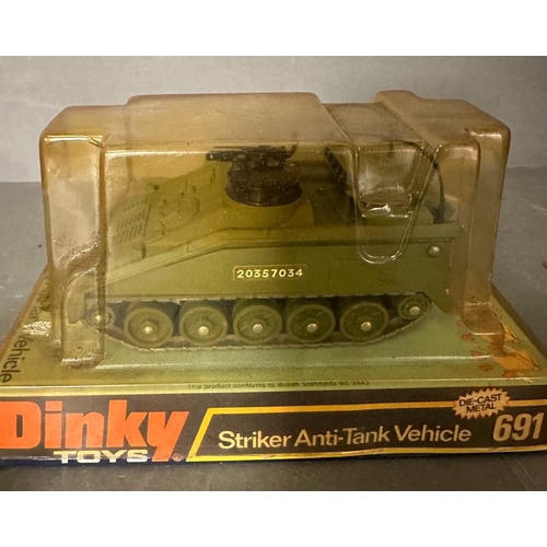 725 - A selection of toy vehicles to include a boxed Dinkey striker anti-tank vehicles and three Britain's... 