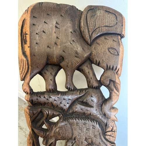 96 - A carved African birthing chair with elephant and rhino detail