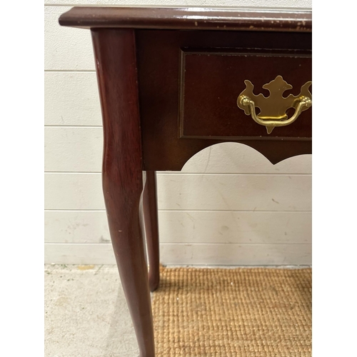 115 - A three drawer magnolia console table with brass drop down handles (H69cm W92cm D31cm)