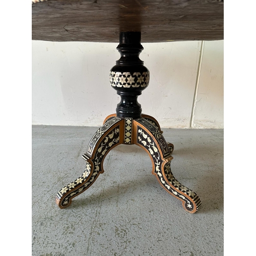 121 - A Moroccan style low pedestal table on splayed legs with geometrical mother of pearl and ebony inlay... 