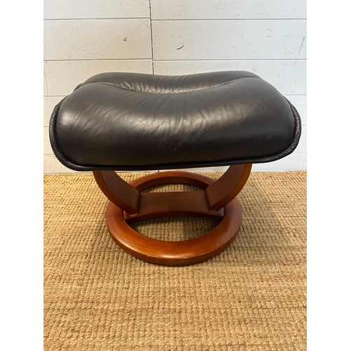 165 - A black leather ergonomic stressless arm chair and matching foot stool