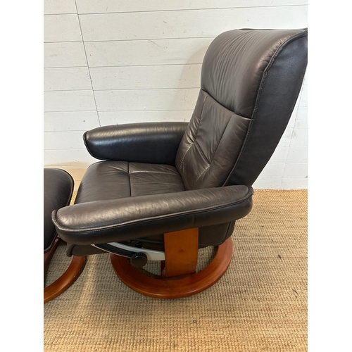 165 - A black leather ergonomic stressless arm chair and matching foot stool