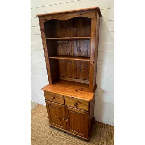 174 - A pine dresser with open shelves upon a cupboard base (H180cmW80cm D43cm)