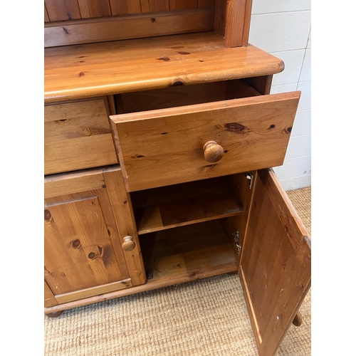 174 - A pine dresser with open shelves upon a cupboard base (H180cmW80cm D43cm)