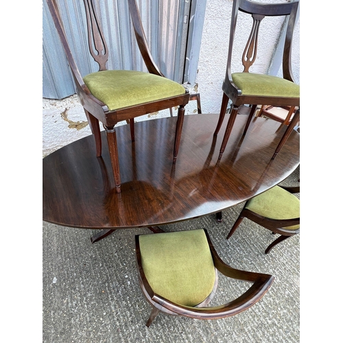 178 - An oval dining table on twin pedestal and castors with six stylish curved chairs