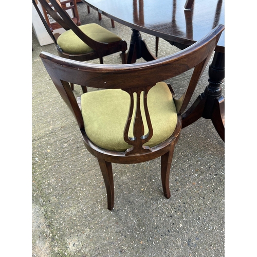 178 - An oval dining table on twin pedestal and castors with six stylish curved chairs