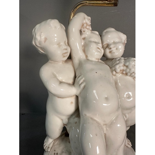 236 - A white ceramic figural cherub table lamp on gold painted base