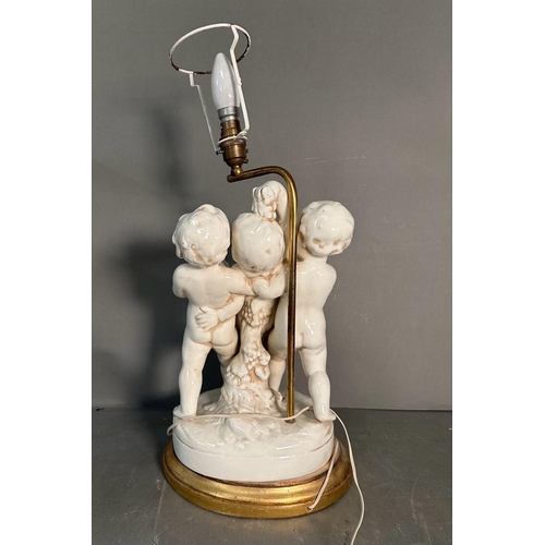 236 - A white ceramic figural cherub table lamp on gold painted base