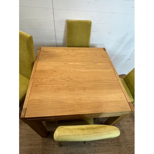 25 - A light oak dining table and four lime green chairs (H75cm Sq85cm)