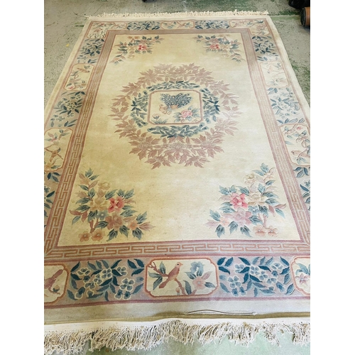 251 - A wool rug with white grounds and central flower shield and geometric boarder (186cm x 280cm)