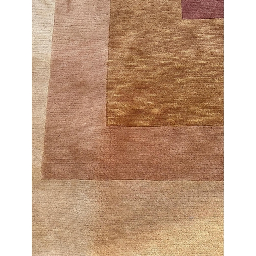 252 - A beige ground wool rug in red, brown and orange 300cm x 210cm