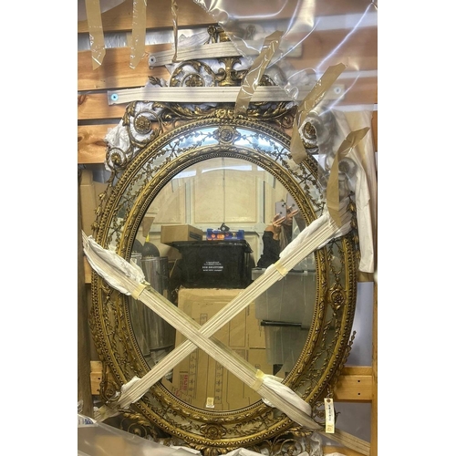 256 - A large George lll gilt wood oval mirror. The frame with urn cresting and floral and foliate scrolls... 