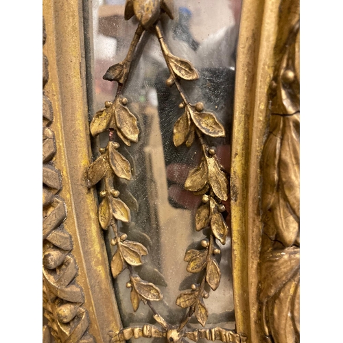 256 - A large George lll gilt wood oval mirror. The frame with urn cresting and floral and foliate scrolls... 