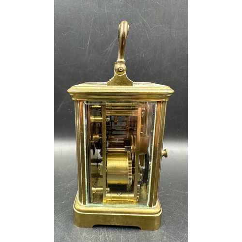 271 - A French brass cased carriage clock with glass panes to side and back