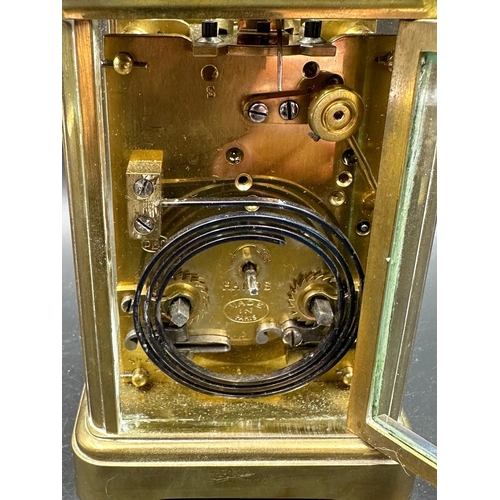 271 - A French brass cased carriage clock with glass panes to side and back